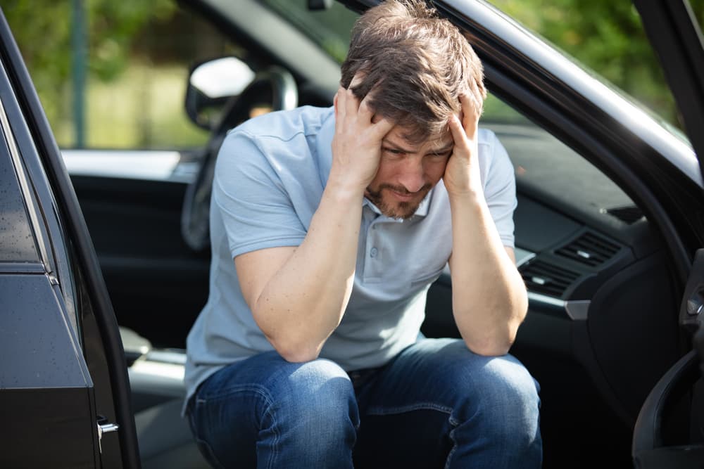un hombre sufre dolor de cabeza tras un accidente de tráfico