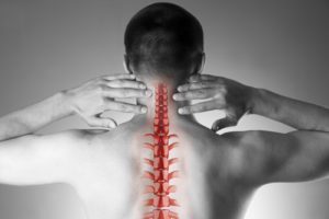 Spine pain, man with backache and ache in the neck, black and white photo with red backbone on gray background