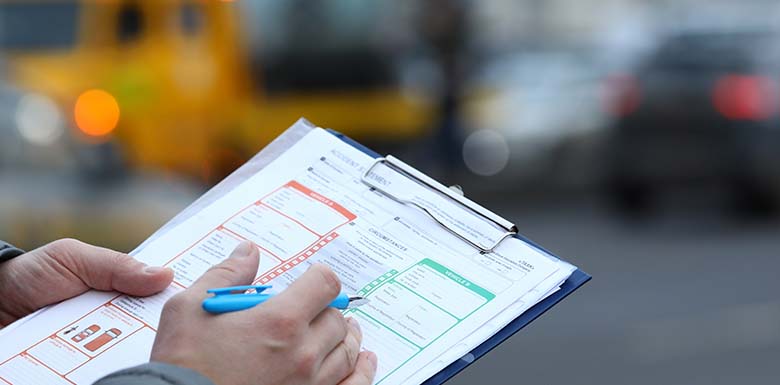 Man filling out crash report on clipboard